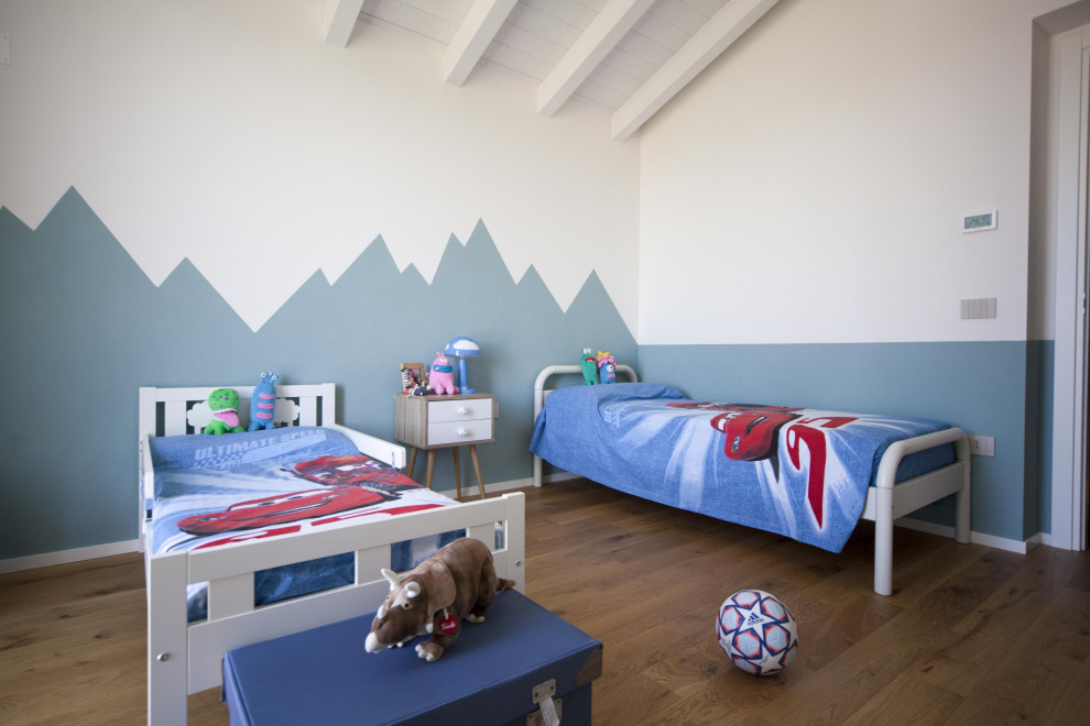 Foto di una cameretta per bambini da 4 a 10 anni nordica di medie dimensioni con pareti verdi, pavimento in legno massello medio, travi a vista e pareti in legno