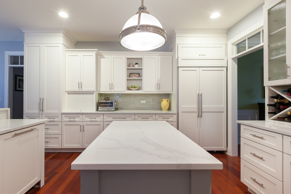 Large transitional u-shaped eat-in kitchen in Chicago with an undermount sink, shaker cabinets, white cabinets, quartz benchtops, grey splashback, glass tile splashback, stainless steel appliances, medium hardwood floors, with island and red floor.