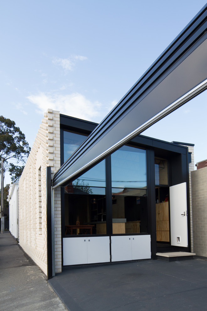 Photo of a contemporary one-storey brick white exterior in Melbourne with a flat roof.