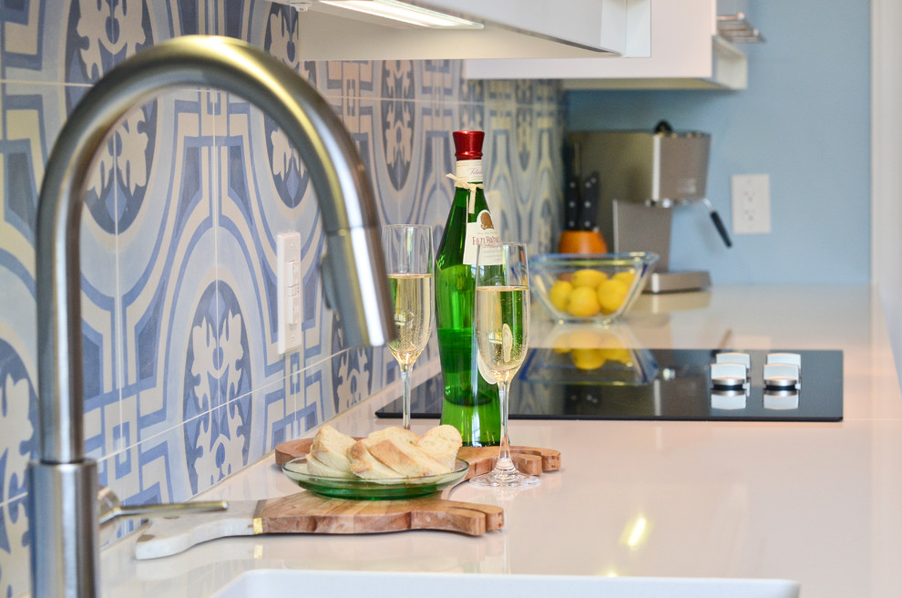 Example of a mid-sized minimalist l-shaped cork floor eat-in kitchen design in Ottawa with an undermount sink, flat-panel cabinets, white cabinets, quartzite countertops, blue backsplash, porcelain backsplash, stainless steel appliances and an island
