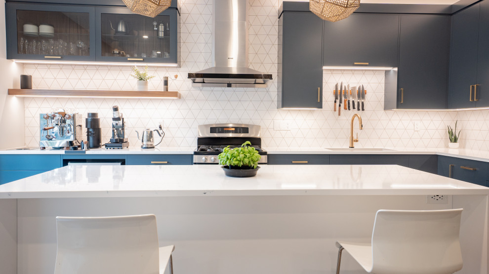 Example of a minimalist l-shaped vinyl floor and beige floor open concept kitchen design in Toronto with flat-panel cabinets, blue cabinets, quartz countertops, white backsplash, ceramic backsplash, stainless steel appliances, an island and white countertops