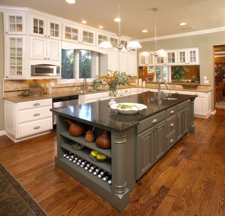 Example of a large transitional l-shaped medium tone wood floor and brown floor kitchen design in Denver with raised-panel cabinets, white cabinets, stainless steel appliances, an island, an undermount sink, granite countertops, beige backsplash and ceramic backsplash