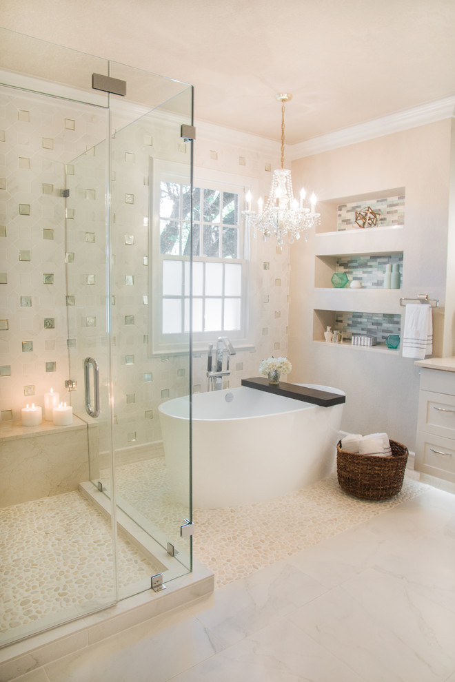 Design ideas for a mid-sized contemporary master bathroom in Austin with recessed-panel cabinets, beige cabinets, a freestanding tub, a corner shower, beige tile, pebble tile, beige walls, pebble tile floors and a vessel sink.