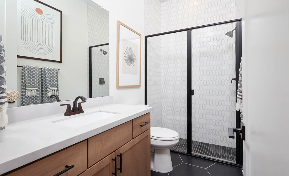Design ideas for a contemporary shower room bathroom in Austin with recessed-panel cabinets, medium wood cabinets, an alcove shower, white tiles, white walls, porcelain flooring, a submerged sink, black floors, a hinged door, white worktops, a single sink and a built in vanity unit.