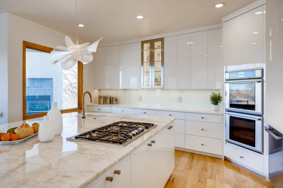 Inspiration for a large contemporary l-shaped open plan kitchen in Denver with a single-bowl sink, flat-panel cabinets, white cabinets, quartzite benchtops, green splashback, glass sheet splashback, stainless steel appliances, light hardwood floors, with island, yellow floor and white benchtop.