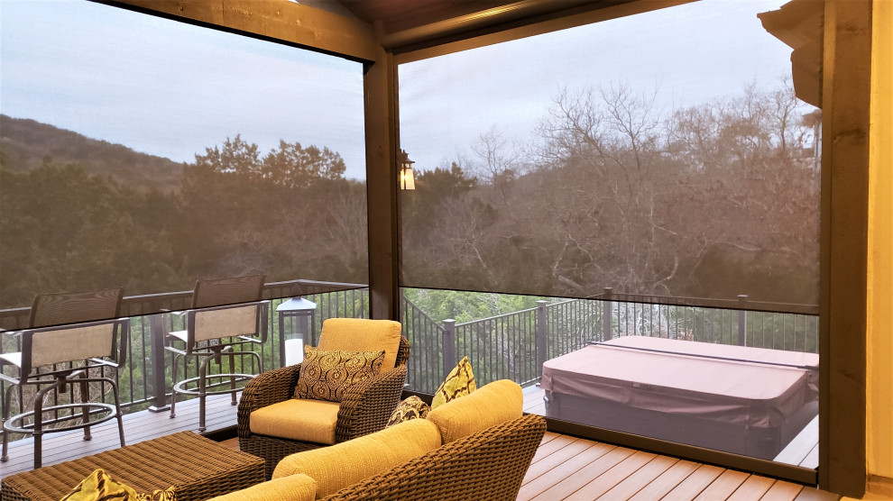 Design ideas for a large country backyard and first floor deck in Austin with a roof extension and metal railing.