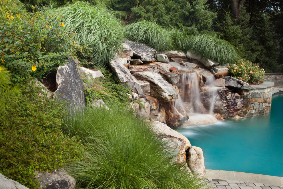 Design ideas for a large country backyard pool in DC Metro with a water feature.