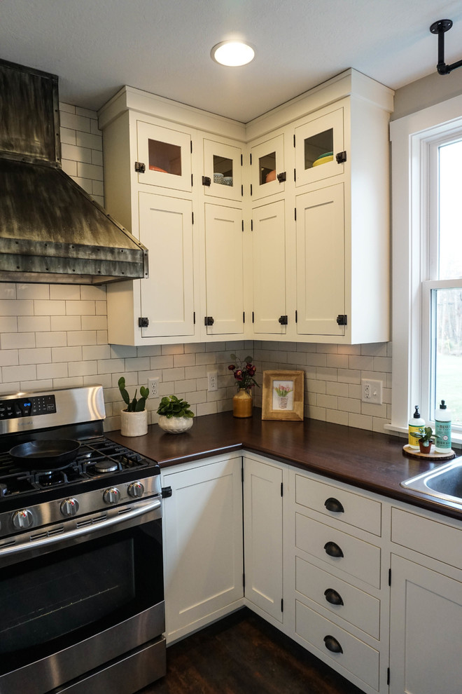 Small country u-shaped kitchen pantry in Columbus with a drop-in sink, shaker cabinets, white cabinets, white splashback, subway tile splashback, stainless steel appliances, dark hardwood floors, with island, brown floor and zinc benchtops.