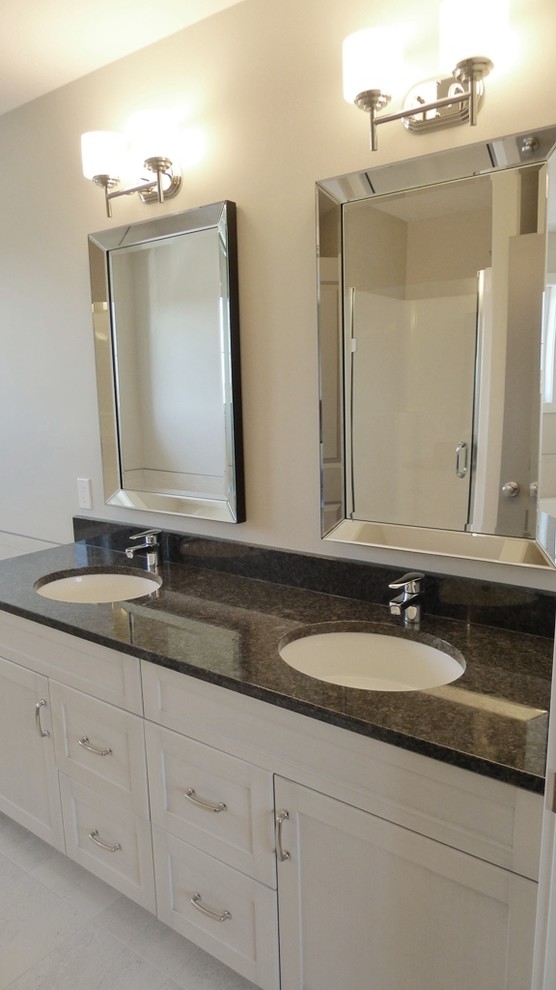 Inspiration for a small transitional master porcelain tile and white tile porcelain tile drop-in bathtub remodel with an undermount sink, shaker cabinets, white cabinets, granite countertops, beige walls, a two-piece toilet and a drop-in sink
