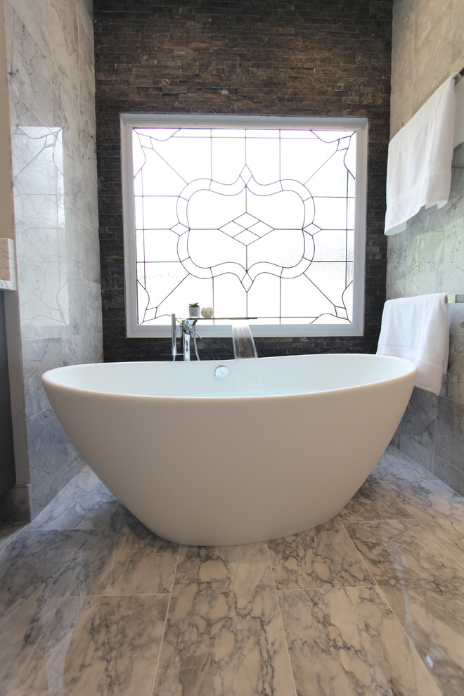 This is an example of a large contemporary master bathroom in Atlanta with shaker cabinets, grey cabinets, a freestanding tub, a curbless shower, a two-piece toilet, black and white tile, gray tile, white tile, stone tile, grey walls, marble floors, an undermount sink and marble benchtops.