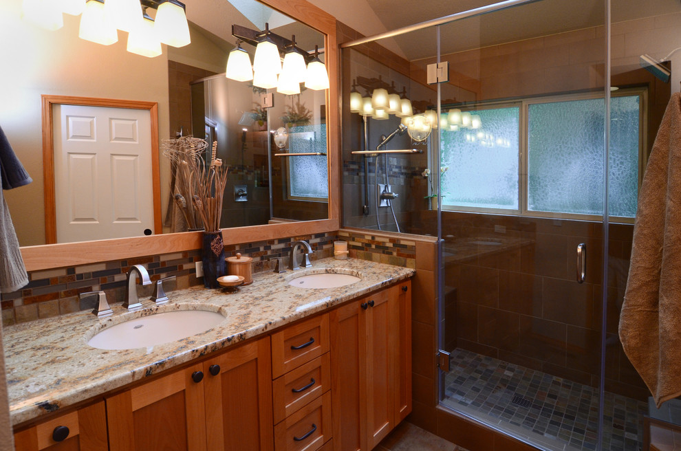 This is an example of an arts and crafts bathroom in Portland with an undermount sink, shaker cabinets, medium wood cabinets, granite benchtops, an alcove shower, multi-coloured tile and beige walls.