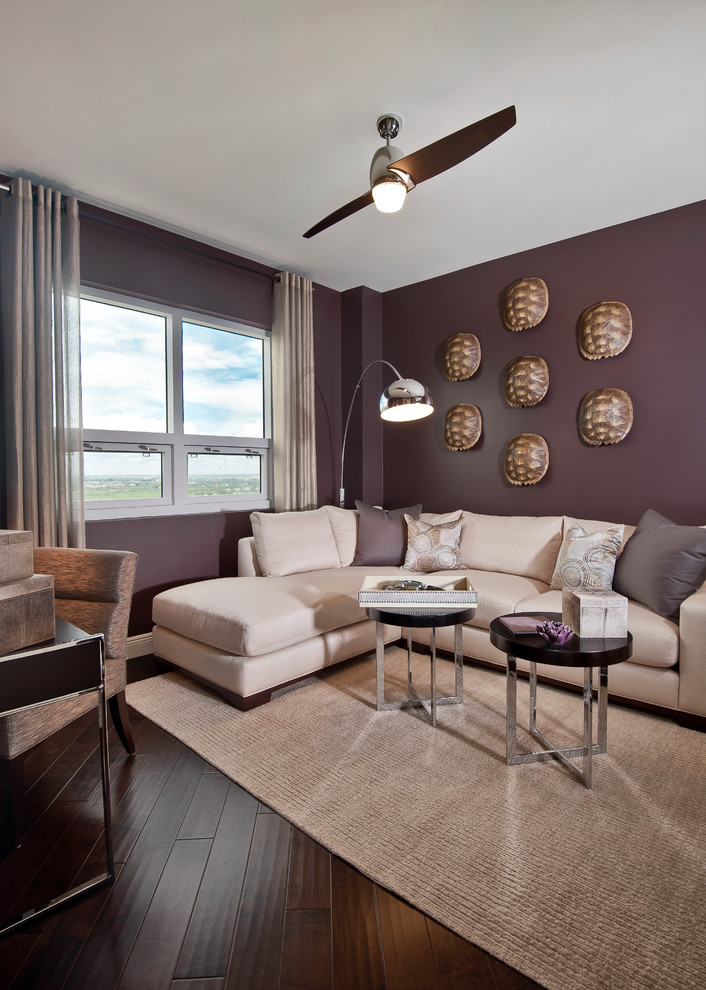 Photo of a contemporary living room in Miami with purple walls and dark hardwood floors.