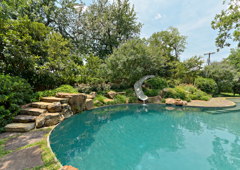 Design ideas for an eclectic custom-shaped pool in Dallas with a water slide.