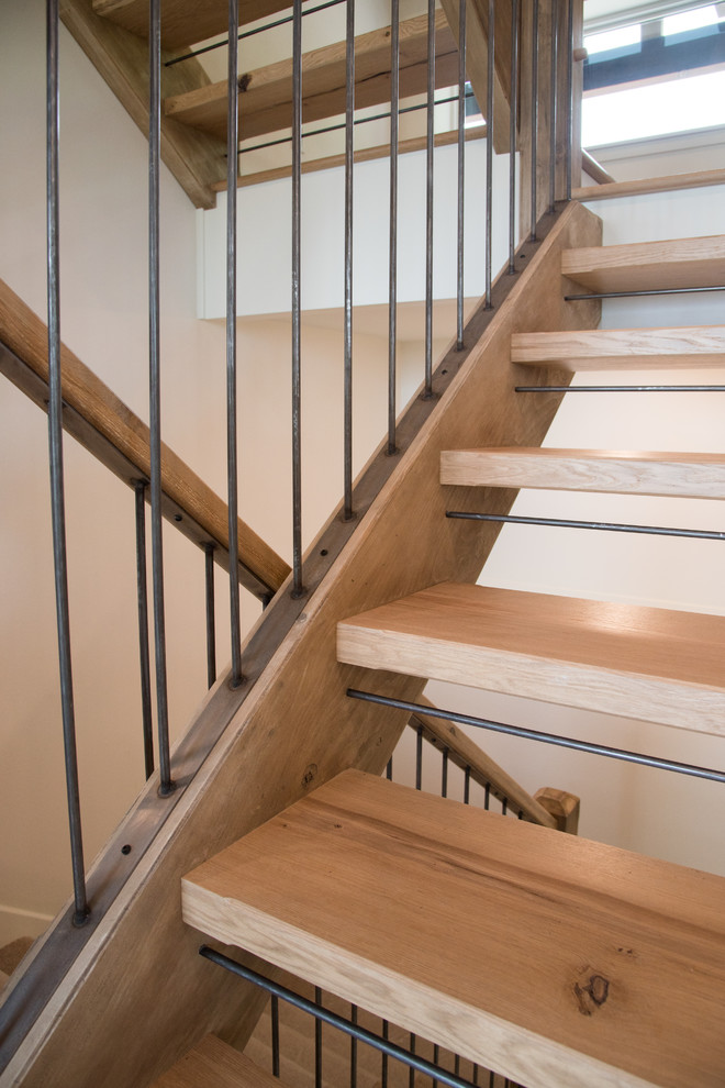 This is an example of a mid-sized country wood u-shaped staircase in Minneapolis with open risers and mixed railing.
