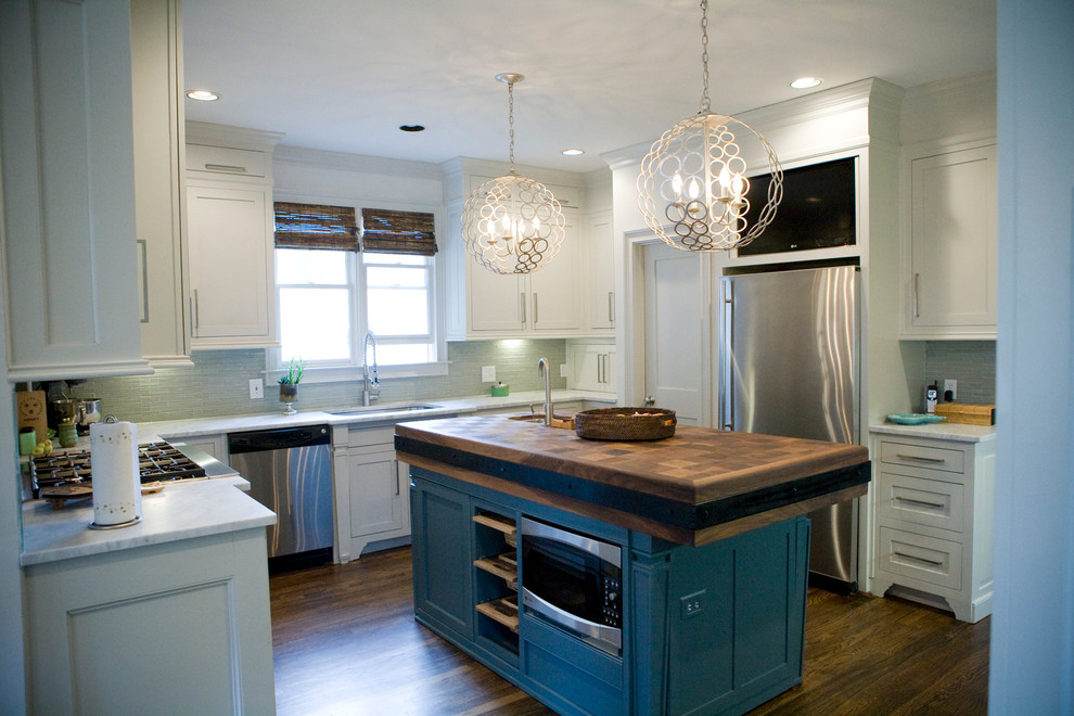 Inspiration for a mid-sized eclectic l-shaped separate kitchen in Atlanta with an undermount sink, recessed-panel cabinets, yellow cabinets, marble benchtops, white splashback, glass tile splashback, stainless steel appliances, dark hardwood floors and with island.