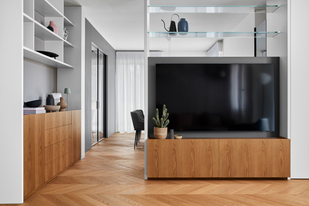 Photo of a contemporary family room in Milan with light hardwood floors and a built-in media wall.