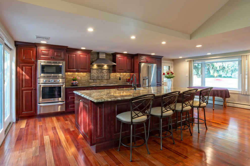 Eat-in kitchen - large transitional single-wall light wood floor and brown floor eat-in kitchen idea in Philadelphia with an undermount sink, raised-panel cabinets, red cabinets, granite countertops, brown backsplash, porcelain backsplash, stainless steel appliances, an island and brown countertops