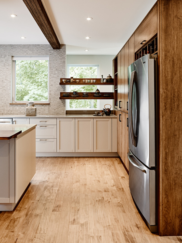 Inspiration for a large transitional l-shaped medium tone wood floor eat-in kitchen remodel with an undermount sink, shaker cabinets, medium tone wood cabinets, quartz countertops, gray backsplash, mosaic tile backsplash, stainless steel appliances and an island