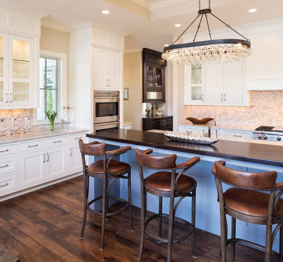 Design ideas for a traditional kitchen in Minneapolis with shaker cabinets, white cabinets, beige splashback, mosaic tile splashback, stainless steel appliances, dark hardwood floors and with island.