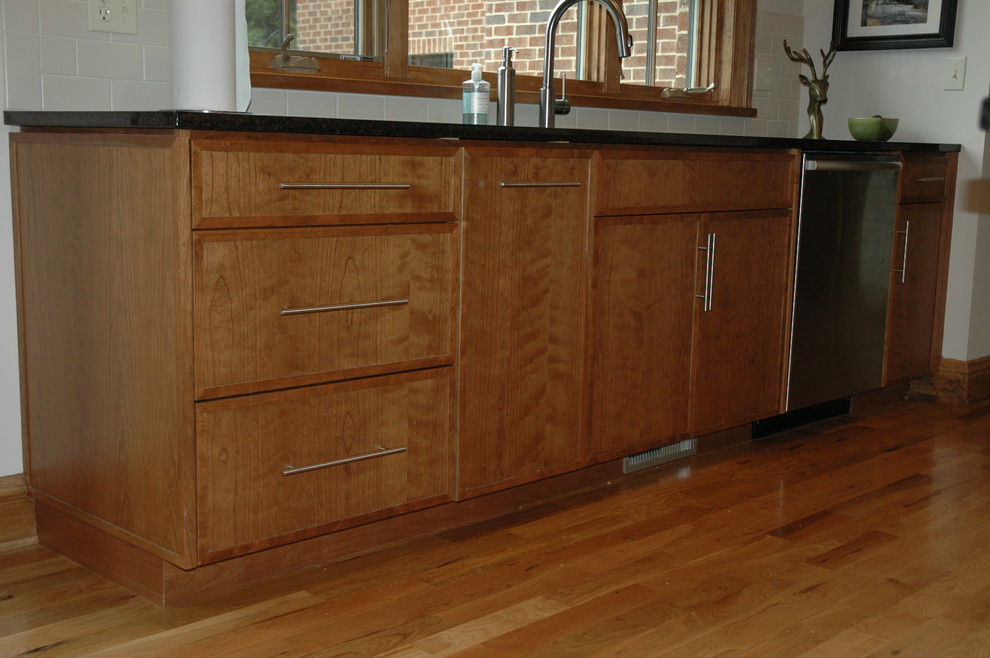 Inspiration for a transitional u-shaped eat-in kitchen remodel with an undermount sink, flat-panel cabinets, laminate countertops, white backsplash and stainless steel appliances