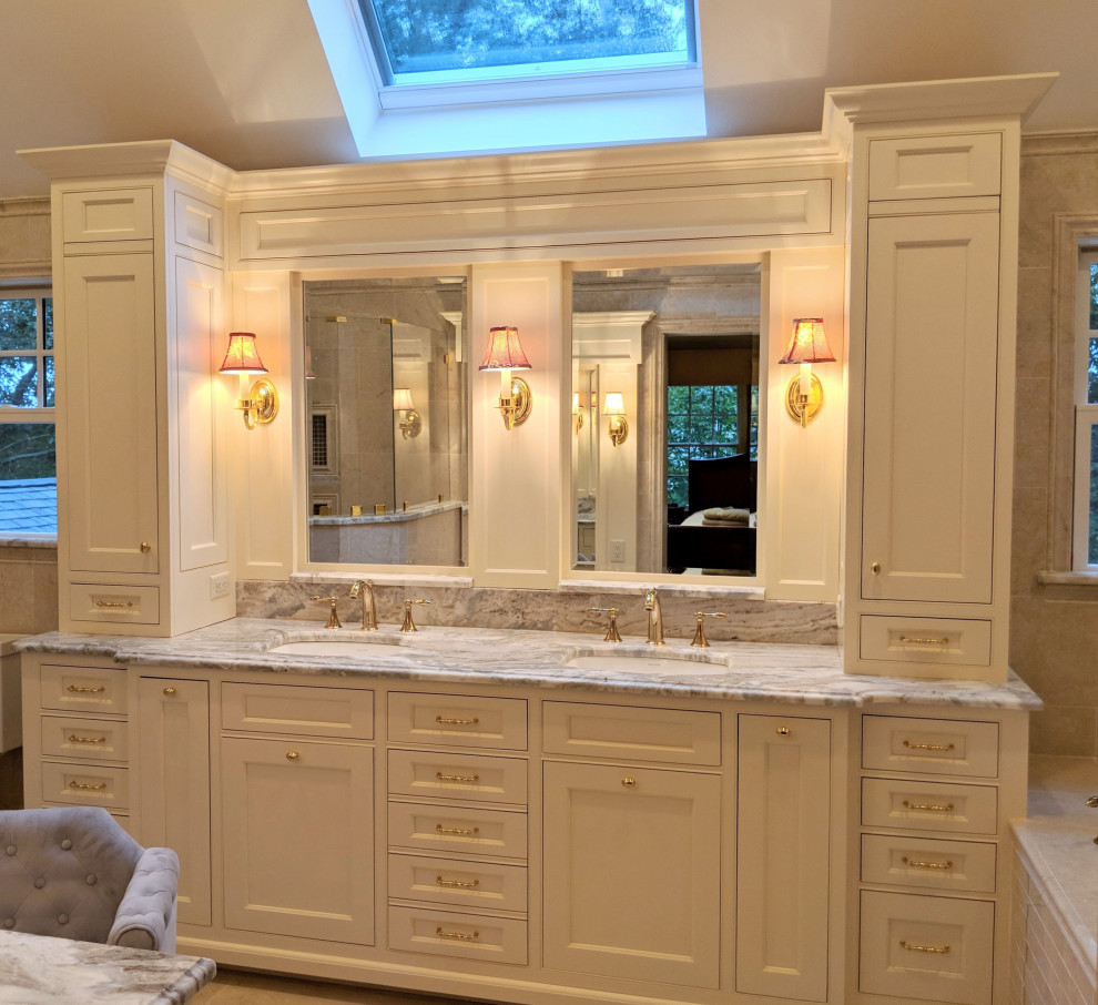 Photo of a large traditional master bathroom in Boston with beaded inset cabinets, white cabinets, a drop-in tub, a corner shower, beige tile, porcelain tile, beige walls, porcelain floors, an undermount sink, granite benchtops, beige floor, multi-coloured benchtops, a double vanity and a built-in vanity.