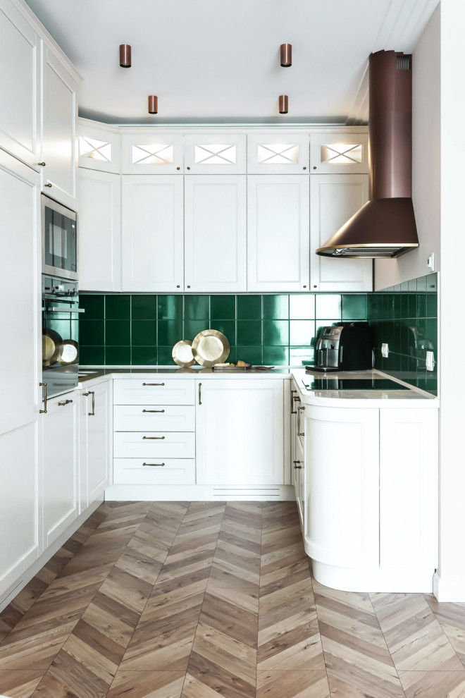 Small transitional u-shaped open plan kitchen in Moscow with an undermount sink, recessed-panel cabinets, white cabinets, quartz benchtops, green splashback, ceramic splashback, stainless steel appliances, laminate floors, beige floor and beige benchtop.