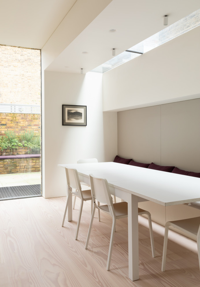 This is an example of a contemporary dining room in London with banquette seating.