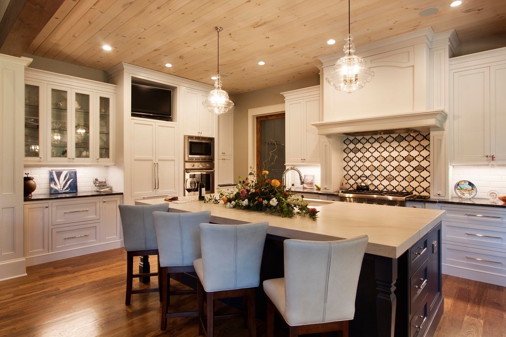 Mid-sized transitional l-shaped medium tone wood floor and brown floor eat-in kitchen photo with an undermount sink, shaker cabinets, blue cabinets, quartzite countertops, multicolored backsplash, glass tile backsplash, stainless steel appliances, an island and white countertops