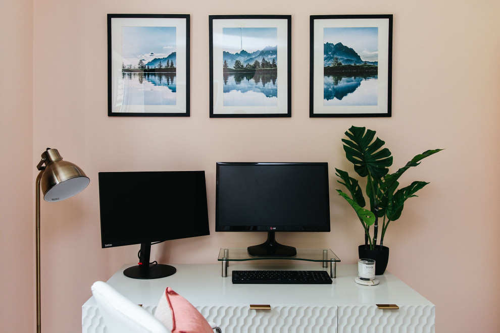 Ejemplo de despacho moderno de tamaño medio con paredes rosas y escritorio independiente