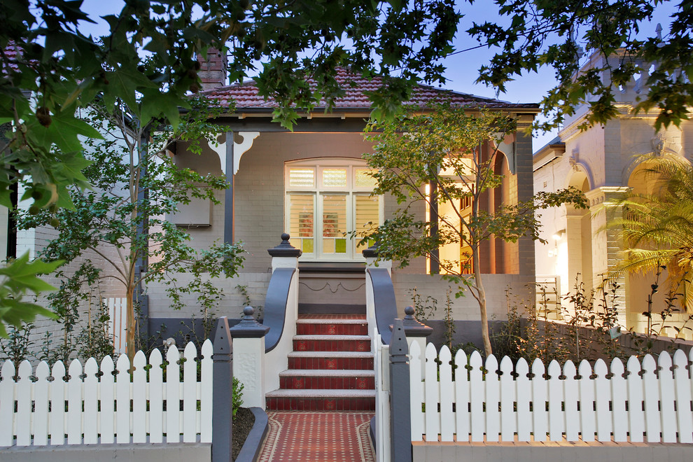 Photo of a transitional one-storey brick beige house exterior in Sydney with a tile roof and a gable roof.