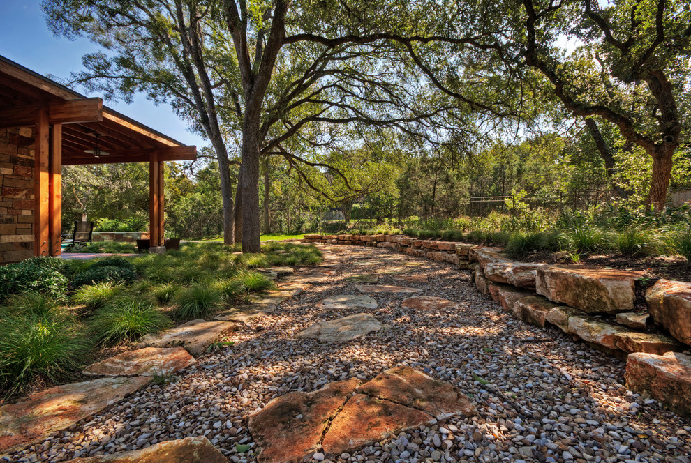 Design ideas for an expansive contemporary backyard garden in Austin with a garden path and river rock.