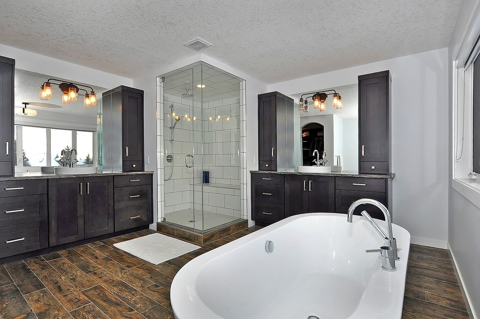 Design ideas for an expansive country master bathroom in Calgary with shaker cabinets, brown cabinets, a freestanding tub, a corner shower, a two-piece toilet, white tile, ceramic tile, white walls, porcelain floors, a vessel sink, granite benchtops, brown floor and a hinged shower door.