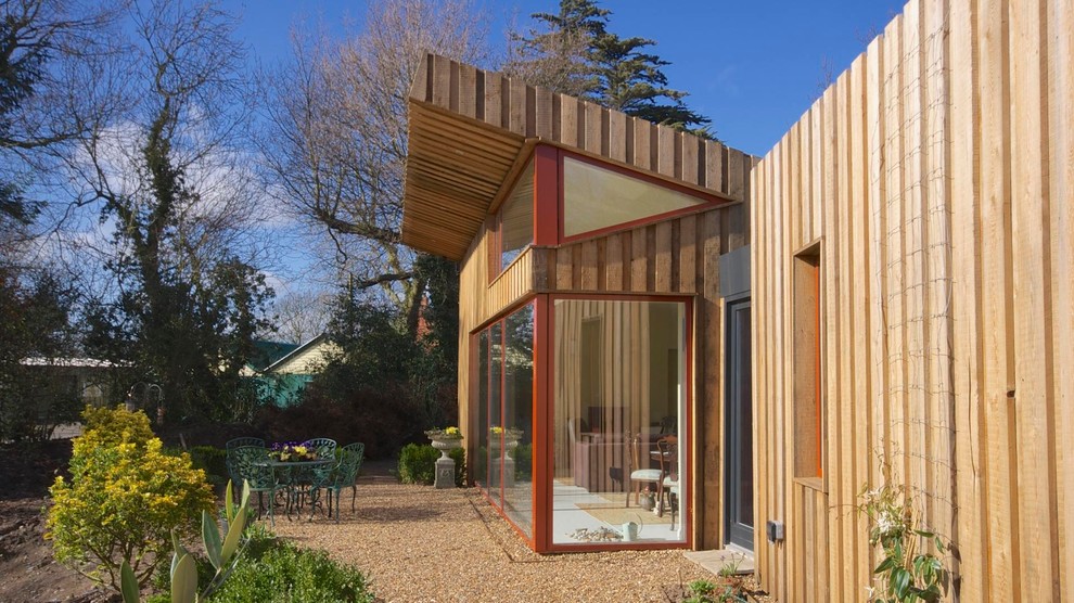 Inspiration for a mid-sized contemporary one-storey yellow exterior in London with wood siding.
