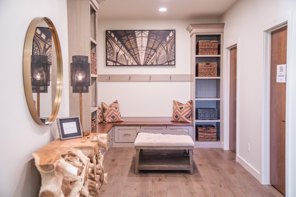 Mudroom - large transitional medium tone wood floor and brown floor mudroom idea with white walls and a medium wood front door
