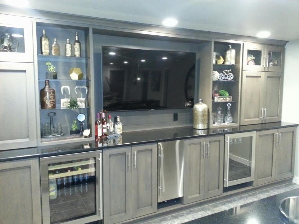 Inspiration for a large traditional single-wall wet bar in Other with a drop-in sink, shaker cabinets, light wood cabinets and light hardwood floors.