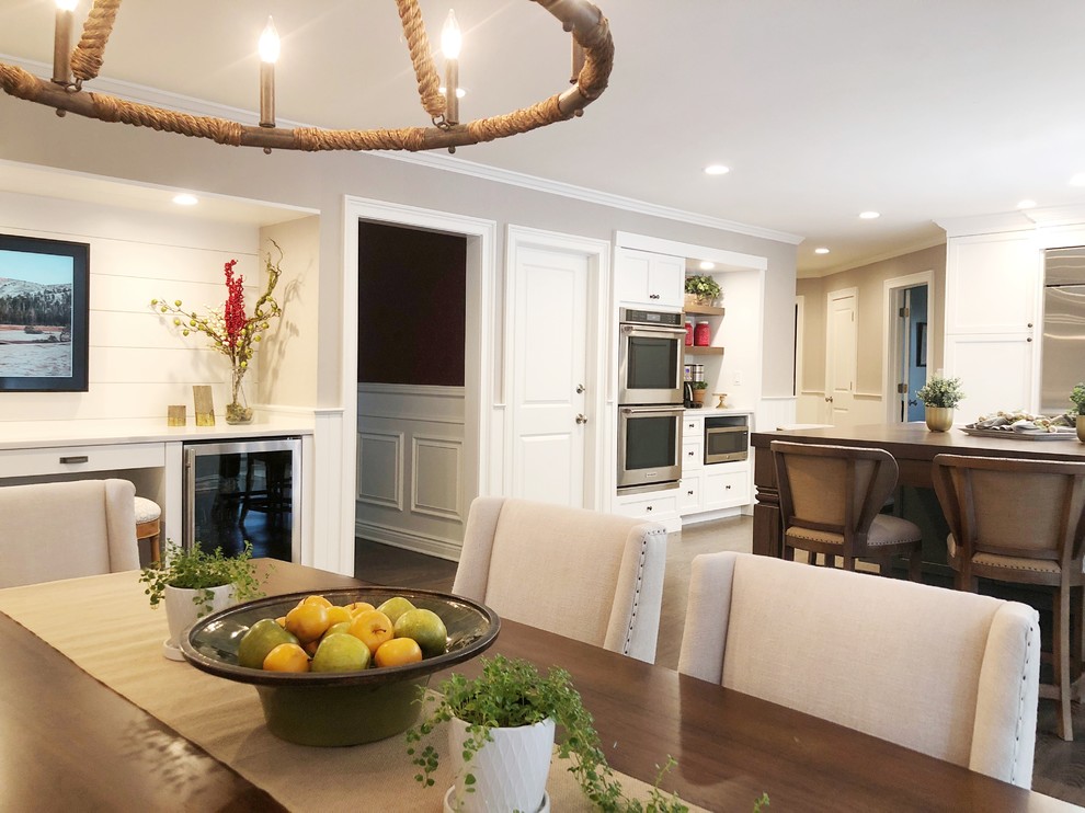 Eat-in kitchen - huge transitional dark wood floor and brown floor eat-in kitchen idea with an undermount sink, shaker cabinets, white cabinets, quartz countertops, white backsplash, porcelain backsplash, stainless steel appliances, an island and white countertops