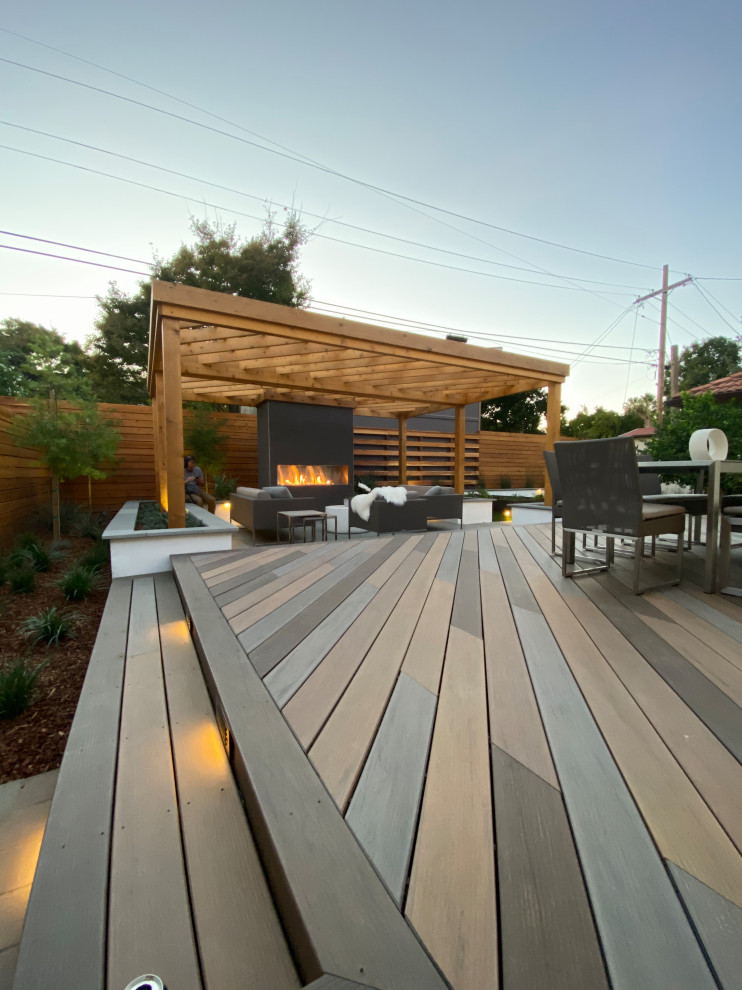 Design ideas for a mid-sized modern backyard deck in Richmond with with fireplace and a pergola.