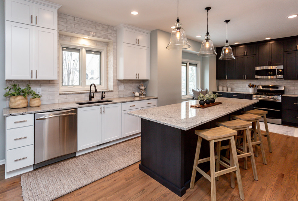 Inspiration for a large transitional u-shaped medium tone wood floor and brown floor eat-in kitchen remodel with an undermount sink, recessed-panel cabinets, white cabinets, granite countertops, white backsplash, subway tile backsplash, stainless steel appliances, an island and gray countertops