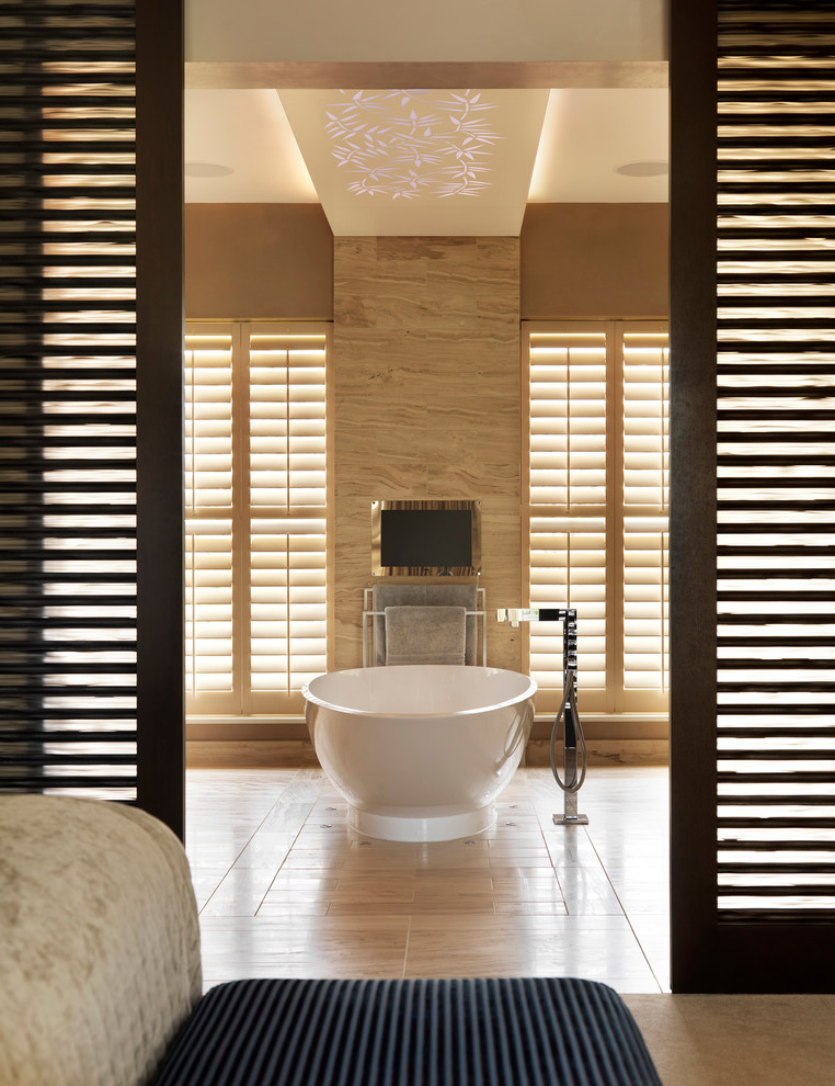 Photo of a large contemporary master bathroom in London with a freestanding tub.