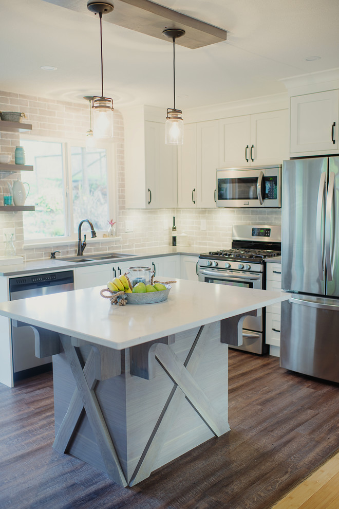 Inspiration for a mid-sized transitional l-shaped brown floor eat-in kitchen remodel in Vancouver with an undermount sink, shaker cabinets, white cabinets, quartz countertops, gray backsplash, stainless steel appliances, an island, porcelain backsplash and white countertops