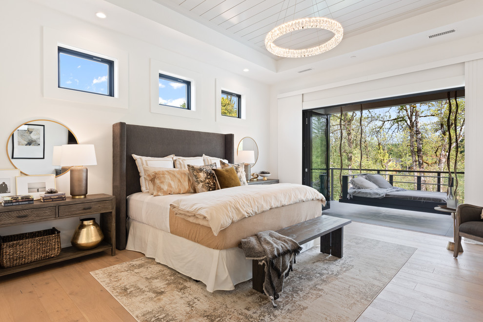 Transitional bedroom in Portland with white walls, medium hardwood floors and brown floor.