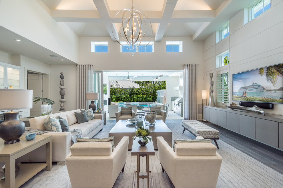 Inspiration for a beach style open concept family room in Miami with white walls, dark hardwood floors, no fireplace and a wall-mounted tv.