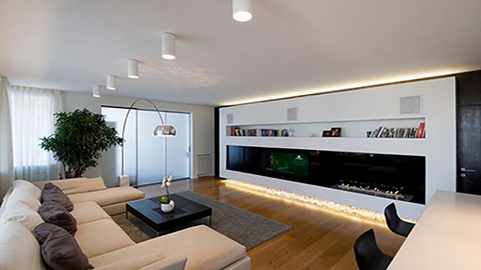 Стильный дизайн: большая открытая гостиная комната в стиле модернизм с музыкальной комнатой, светлым паркетным полом и горизонтальным камином - последний тренд