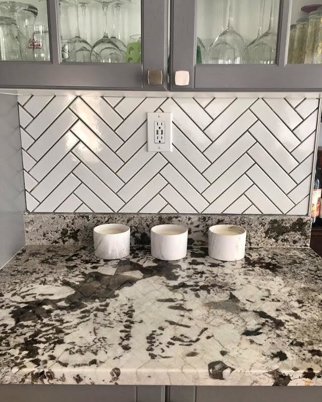 Small transitional single-wall home design photo with an undermount sink, glass-front cabinets, gray cabinets, granite countertops, white backsplash and ceramic backsplash