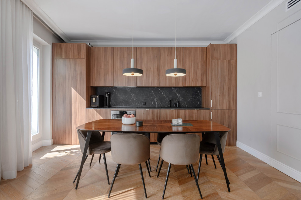 Inspiration for a mid-sized contemporary single-wall open plan kitchen in Marseille with an undermount sink, beaded inset cabinets, medium wood cabinets, wood benchtops, black splashback, timber splashback, light hardwood floors and black benchtop.