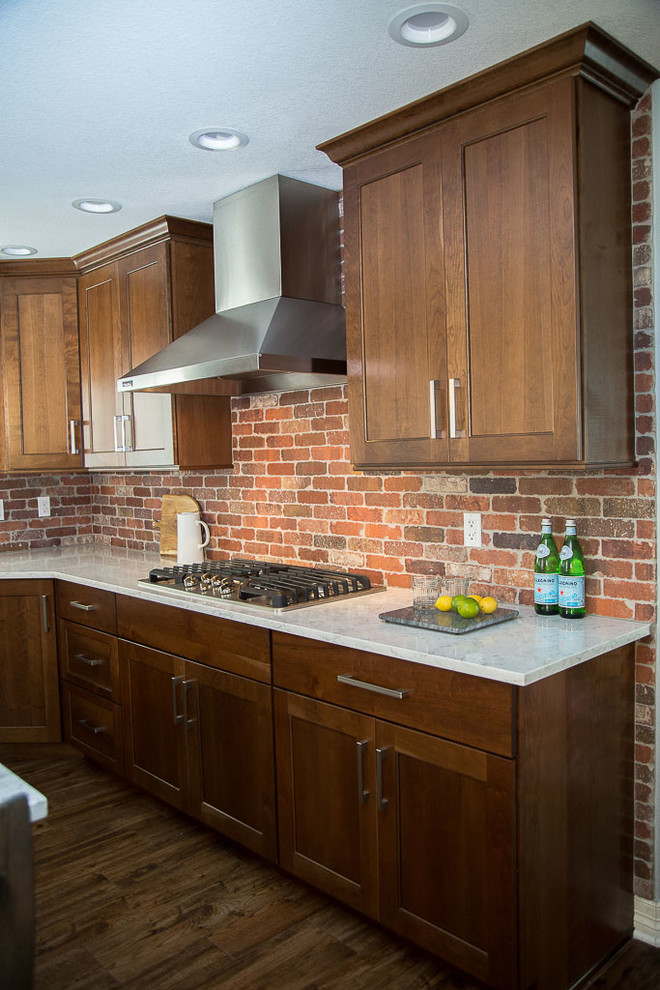 Inspiration for a large transitional l-shaped dark wood floor eat-in kitchen remodel in Denver with a farmhouse sink, shaker cabinets, dark wood cabinets, quartz countertops, red backsplash, terra-cotta backsplash, stainless steel appliances and an island