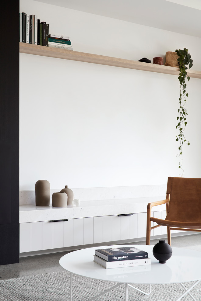 This is an example of a contemporary living room in Melbourne with concrete floors and a standard fireplace.