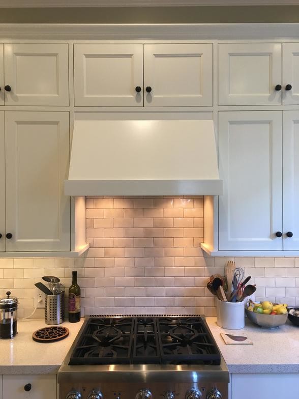 This is an example of a mid-sized traditional u-shaped eat-in kitchen in San Francisco with a single-bowl sink, shaker cabinets, white splashback, glass tile splashback, stainless steel appliances, medium hardwood floors and no island.