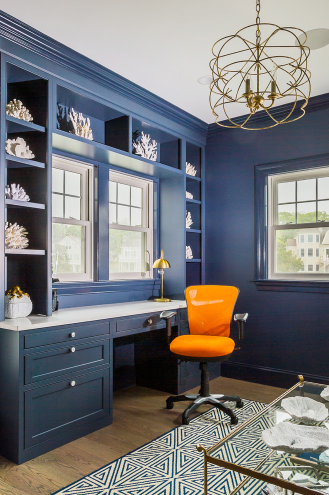 Design ideas for a large transitional study room in Boston with blue walls, light hardwood floors, a built-in desk and beige floor.