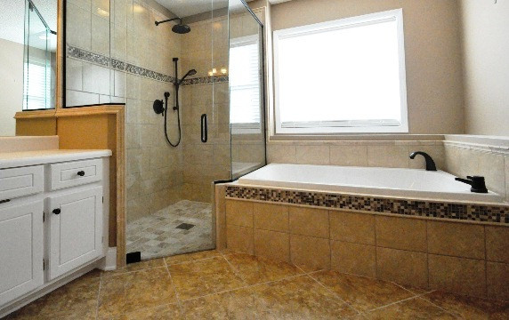 Cette image montre une salle de bain principale traditionnelle avec un placard avec porte à panneau surélevé, des portes de placard blanches, un plan de toilette en acier inoxydable, une douche à l'italienne, un carrelage beige, des carreaux de porcelaine, un mur beige et un sol en carrelage de porcelaine.